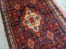 SAROUK RUNNER, ivory medallion and scattered lozenges and peacocks to the geometric indigo field,