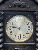 CIRCA 1930 CARVED OAK LONGCASE CLOCK with barley twist Corinthian cap front detail, chime strike