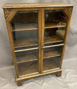 VINTAGE OAK TWO DOOR GLAZED BOOKCASE having bevelled edging to the glass and interior adjustable