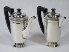 A PAIR OF SILVER COFFEE POTS - plain bodies on a pedestal base with stepped top, handles and knops