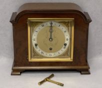 ELLIOTT OF LONDON WALNUT CASED MANTEL CLOCK - having winged mask spandrels and silvered chapter ring