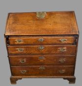 BUREAU - Georgian oak having a sloped front with large brass lock plate revealing a centre open