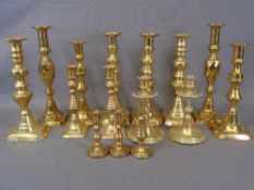 BRASS CANDLESTICKS - seven pairs and one odd, graduated from 27.5cms the tallest