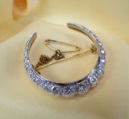 YELLOW & WHITE METAL DIAMOND CRESCENT BROOCH, set with nineteen graduated diamonds, 7.8gms