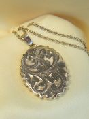 9CT GOLD OVAL LOCKET, scroll engraved, on 9ct gold fine chain, 60cms long, 12.4gms overall