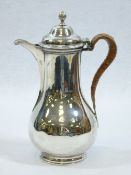 SILVER COFFEE POT - of bulbous form with narrow neck and hinged lid with swirled knop, on a short