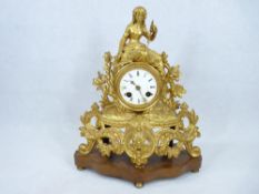 19TH CENTURY FRENCH GILT METAL MANTEL CLOCK - Rococo style on a shaped walnut base with bun feet