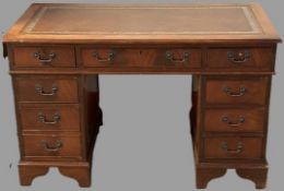 REPRODUCTION MAHOGANY PEDESTAL DESK with gilt tooled leather top, three frieze drawers and twin