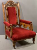 EDWARDIAN GENT'S EASY CHAIR with carved back on turned front supports with castors and red velour