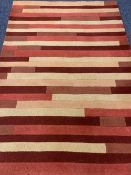 MODERN HAND LOOMED INDIAN WOOL PILE RUG having tonal reds and creams in a repeating block pattern,