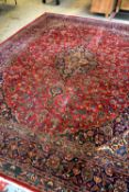 KASHAN-STYLE CARPET, with central medallion suspending pendants, on a red field of scrolling