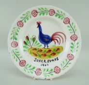 A LLANELLY COCKEREL PLATE WITH DEDICATION to John R Evans, 1907 in black, the cockerel standing on a