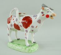 A RARE LLANELLY COW CREAMER in the familiar Swansea style with tail as loop handle and standing over