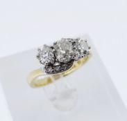 18CT OLD THREE STONE DIAMOND RING, the three primary stones (totalling 1.0cts approx.) on a twist
