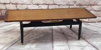 E.GOMME FOR G-PLAN, TEAK 'LONGJOHN' COFFEE TABLE with ebonised base and gilt metal adjustable