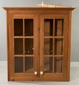 ANTIQUE EFFECT PINE TWO DOOR GLAZED WALL HANGING CORNER CUPBOARD with interior glass shelving,