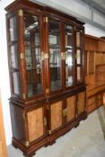 A modern Oriental hardwood bookcase having brass clasps and handles and table and chairs
