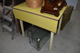 A vintage formica topped drop leaf kitchen table