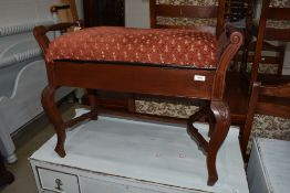 A traditional stained frame piano stool