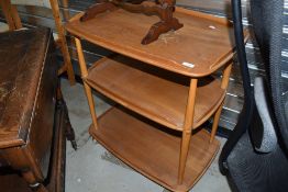 A light stained Ercol tea trolley on shepherds casters, badly marked to top