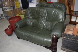 A pair of modern green leather settees, in wooden frames, the seats are removable from the frames