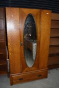 An early 20th Century oak mirror door wardrobe, no base or top plinth