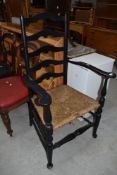 A traditional rush seated ladder back carver chair