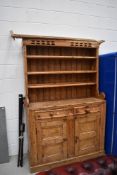 A rustic kitchen dresser, double cupboard and drawer base with plate rack back, approx. width 127cm