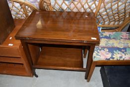 A vintage sapele tea trolley having fold over card table top, closed dimensions approx. 65 x 45cm