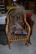A wickerwork armchair and Art Nouveau style cushions