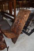 A traditional heavy ethnic wood hand carved African Palavar chair having tree detail to back
