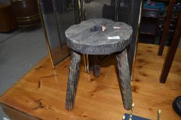 A rustic legged milking stool