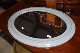 A modern moulded plastic oval wall mirror, in grey, approx. 74cm x 54cm , currently strung in