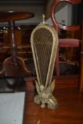 A brass peacock fan style firescreen, having 9 sections