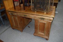 A large rustic pine twin pedestal desk, having ornate brass handles, width approx. 140cm depth 88cm