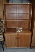 A light Ercol dresser of small proportions having plate rack back over double cupboard, on shepherds