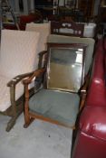 A traditional mahogany framed rocking chair having shaped arms and part turned frame