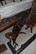 A traditional African palavar chair having carved detail to back