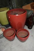 Three red glazed planters, largest being a height of 60cm