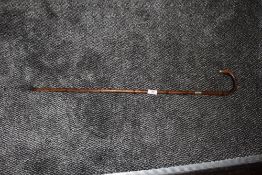 A bent wood bamboo walking cane having HM silver ferrule and tip