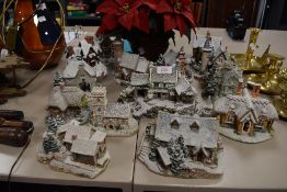 A collection of snowy scene Lilliput lanes and a fake poinsettia.