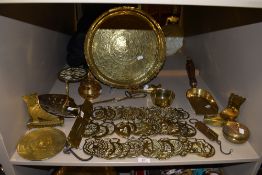 A collection of horse brasses, trivets and coal scoop and more