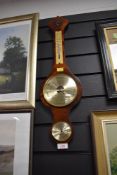 A traditional wooden wall mounted barometer.