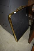 A traditional brass folding fire guard