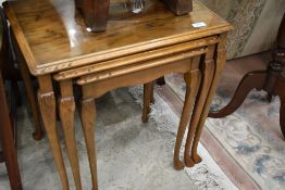 An early 20th Century walnut nest of three tables