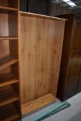 A pine effect laminate bookshelf, approx. width 75cm, height 150cm