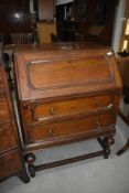 An early 20th Century oak bureau of cushion design, width approx. 73cm