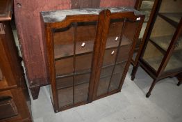 An early 20th Century glazed front oak bookcase bureau top
