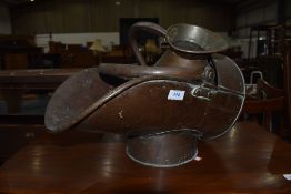 A traditional copper coal helmet and a similar measure