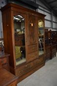 An Edwardian mahogany and inlaid bedroom suite comprising mirror door wardrobe with central press